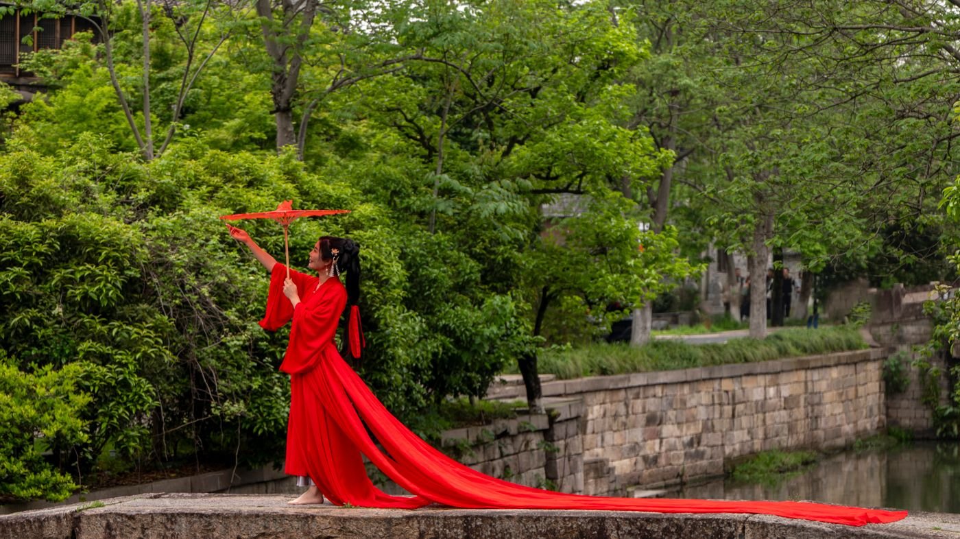 Model in a scarlet dress on the lakeside steps